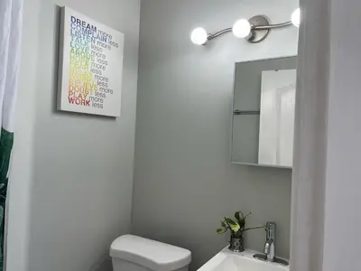 a bathroom with a white toilet and a mirror at Surrey Home - King George Blvd & Rapid Transit - Airport 25 Min - Free Parking & Wi-Fi in Surrey