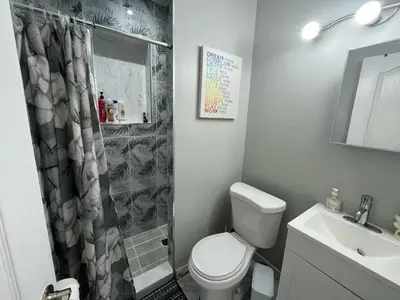 a bathroom with a toilet and a shower and a sink at Surrey Home - King George Blvd & Rapid Transit - Airport 25 Min - Free Parking & Wi-Fi in Surrey