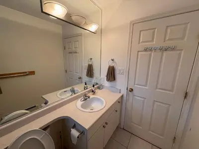 a bathroom with a sink and a toilet and a mirror at Vancouver Guest House - Airport & Downtown 15 Min - Free Parking & Fast Wi-Fi in Vancouver