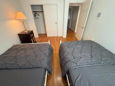 a bedroom with two beds and a lamp on a table at Vancouver Guest House - Airport & Downtown 15 Min - Free Parking & Fast Wi-Fi in Vancouver