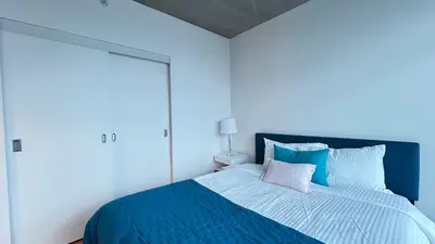 a bedroom with a large bed with blue sheets and pillows at Ocean and Mountain View Home - Downtown Vancouver in Vancouver