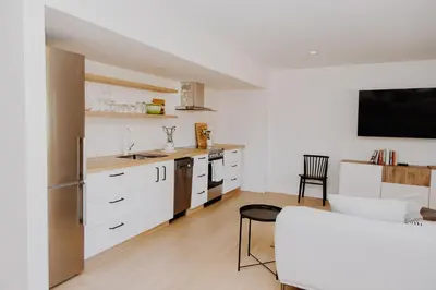 a kitchen with white cabinets and a table and chairs at Luxury 1BR at Red Mountain Ski-Bike Sauna in Rossland