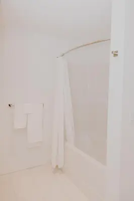 a bathroom with white walls and a shower curtain at Luxury 1BR at Red Mountain Ski-Bike Sauna in Rossland