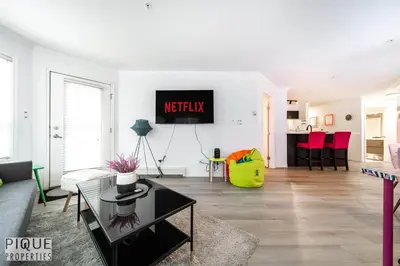 a living room with a couch and a tv on a wall at The Neon Palace - King Bed - Fireplace - Netflix - UGPark in Edmonton
