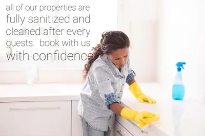 a woman cleaning a counter in a kitchen at The Neon Palace - King Bed - Fireplace - Netflix - UGPark in Edmonton
