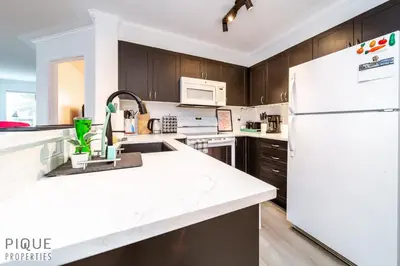 a kitchen with white appliances and a white refrigerator at The Neon Palace - King Bed - Fireplace - Netflix - UGPark in Edmonton