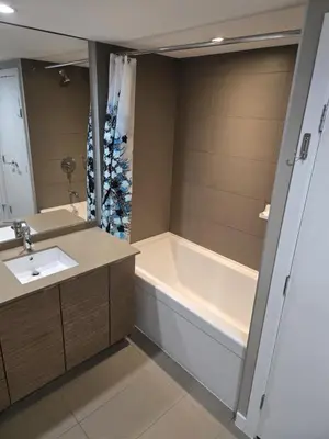 a bathroom with a tub and a sink and a bath tubermottermott at Central Lonsdale Gem in North Vancouver