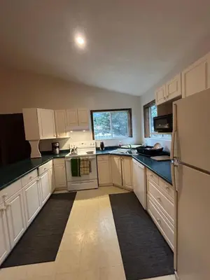 a kitchen with white cabinets and a refrigerator at 3 Bedroom Townhouse in McBride