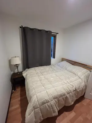 a bedroom with a bed with a gray curtain at 3 Bedroom Townhouse in McBride