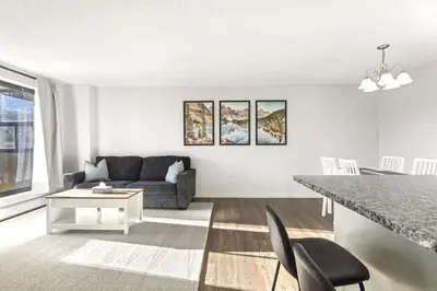 a living room with a couch and a table at Chic & Spacious 2BR at Stampede with Parking, AC in Calgary