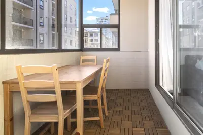 a table and chairs in a room with windows at Chic & Spacious 2BR at Stampede with Parking, AC in Calgary
