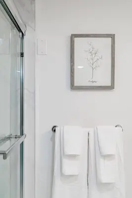 a bathroom with white towels and a picture on the wall at Modern Private 2 BR with 1 bath, 3 beds, West Van in West Vancouver