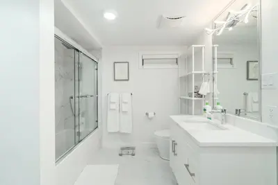 a white bathroom with a sink and a toilet at Modern Private 2 BR with 1 bath, 3 beds, West Van in West Vancouver