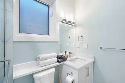 a white bathroom with a sink and a mirror at 2393 Bonaccord Dr - Mattamel in Vancouver