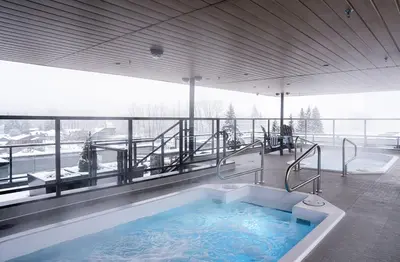 a large bath tub in a room with a balcony at Wooley Terrace by Revelstoke Vacations in Revelstoke