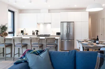 a kitchen and living room with a blue couch at Wooley Terrace by Revelstoke Vacations in Revelstoke