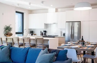 a living room with a blue couch and a kitchen at Wooley Terrace by Revelstoke Vacations in Revelstoke