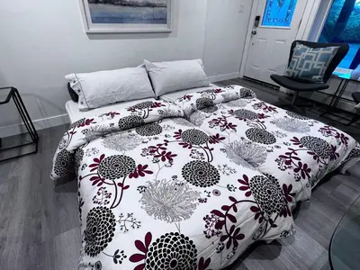 a bedroom with a bed with a flowered comforter at 2BD cozy guest suite in West Vancouver! in West Vancouver