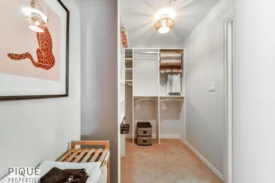 a living room with a couch and a closet at The Breakfast Club Suite - KingBed& AC - Patio - UG Park in Edmonton