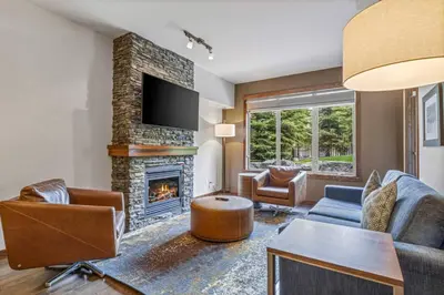 a living room with a couch and a fireplace at Peaceful 1BR Condo with Hot Tub and Pool in Canmore