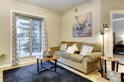 a living room with a couch and a table at Silver Creek 2BR Bliss Hot Tub Access MTN Views in Canmore