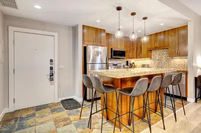 a kitchen with a island with bar stools at Silver Creek 2BR Bliss Hot Tub Access MTN Views in Canmore