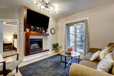 a living room with a couch and a fireplace at Silver Creek 2BR Bliss Hot Tub Access MTN Views in Canmore