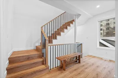 a staircase with a wooden bench in a room with a window at Luxurious Large 3 Bedroom Loft Saskatchewan Drive in Edmonton
