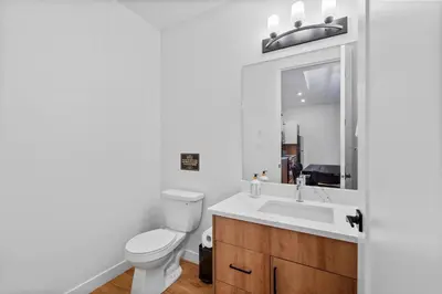 a bathroom with a toilet and a sink and a mirror at Luxurious Large 3 Bedroom Loft Saskatchewan Drive in Edmonton