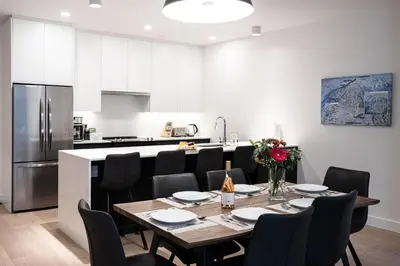 a kitchen with a table and chairs and a refrigerator at Bluebird by Revelstoke Vacations in Revelstoke