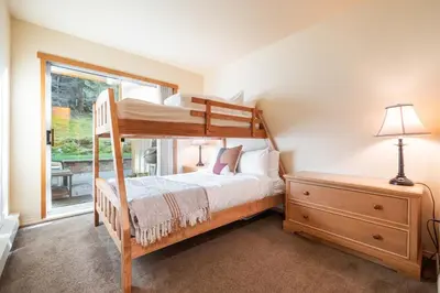 a bedroom with a bunk bed and a window at Wildwood Lodge 113 by Outpost Whistler in Whistler