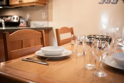 a wooden table with plates and glasses on it at Wildwood Lodge 113 by Outpost Whistler in Whistler