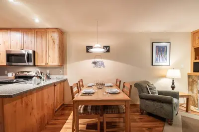 a kitchen with a table and a dining room at Wildwood Lodge 113 by Outpost Whistler in Whistler