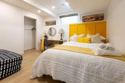 a bedroom with a large bed with a yellow headboard at Cozy Quiet Suite - 2 Bedrooms and 2 Full Bathrooms in Calgary