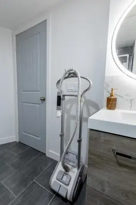 a vacuum cleaner in a bathroom next to a sink at Cozy Quiet Suite - 2 Bedrooms and 2 Full Bathrooms in Calgary