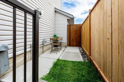 a patio with a table and a fence at Cozy Quiet Suite - 2 Bedrooms and 2 Full Bathrooms in Calgary