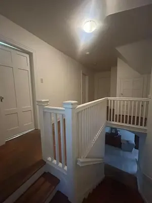 a white staircase in a house with a light at Vancouver Budget Guesthouse - Free Parking, Fast WiFi, Near Airport & Downtown in Vancouver