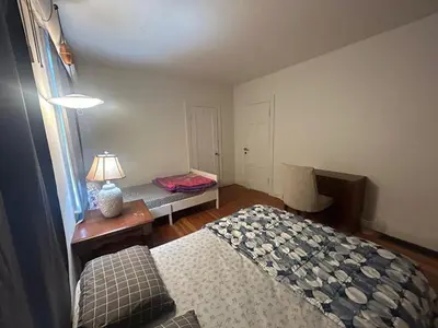 a bedroom with a bed and a table with a lamp at Vancouver Budget Guesthouse - Free Parking, Fast WiFi, Near Airport & Downtown in Vancouver