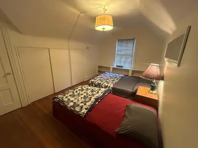 a bedroom with two beds and a tv in it at Vancouver Budget Guesthouse - Free Parking, Fast WiFi, Near Airport & Downtown in Vancouver