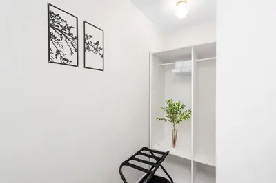 a black chair in a white room with a mirror at NEW Roomy 3BR Family Suite. 5 min to Skytrain. in Vancouver