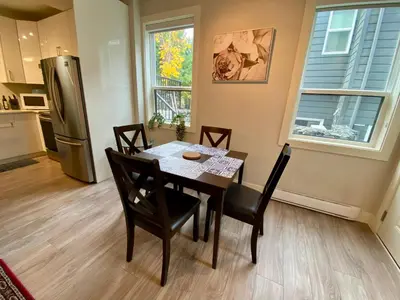 a kitchen with a table and chairs and a refrigerator at Ridge Pointe Retreat Your Victoria Hideaway in Colwood