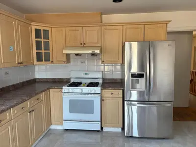 a kitchen with wooden cabinets and a stainless steel refrigerator at Vancouver Budget Stay- Free Parking, Fast WiFi, Near Airport & Downtown 15 Min in Vancouver