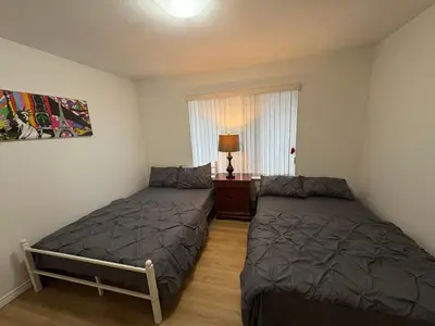 a bedroom with two beds and a window at Vancouver Budget Stay- Free Parking, Fast WiFi, Near Airport & Downtown 15 Min in Vancouver
