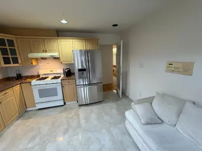 a kitchen with a stainless steel refrigerator and a couch at Vancouver Budget Stay- Free Parking, Fast WiFi, Near Airport & Downtown 15 Min in Vancouver