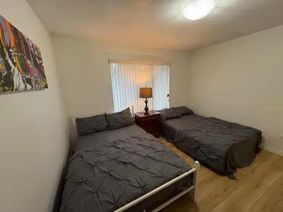 a bedroom with two beds and a window at Vancouver Budget Stay- Free Parking, Fast WiFi, Near Airport & Downtown 15 Min in Vancouver