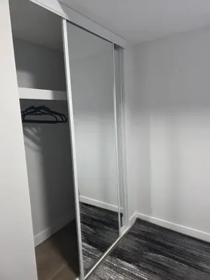 a mirror in a room with a closet at YYC Cozy Suites in Calgary