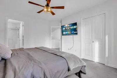 a bedroom with a bed and a ceiling fan at Home Theater•Luxury•Entire4BHome•GamesRoom•KingBed in Edmonton