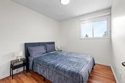 a bedroom with a bed and a window at Quiet & Modern Calgary Stay, Prime Location Near YYC, Free Parking in Calgary