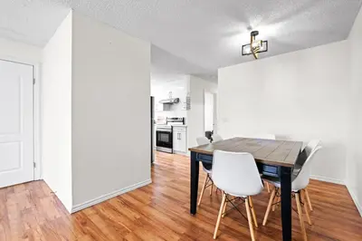 a dining room with a wooden table and white chairs at Quiet & Modern Calgary Stay, Prime Location Near YYC, Free Parking in Calgary
