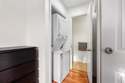 a white laundry room with a washer and dryer at Quiet & Modern Calgary Stay, Prime Location Near YYC, Free Parking in Calgary